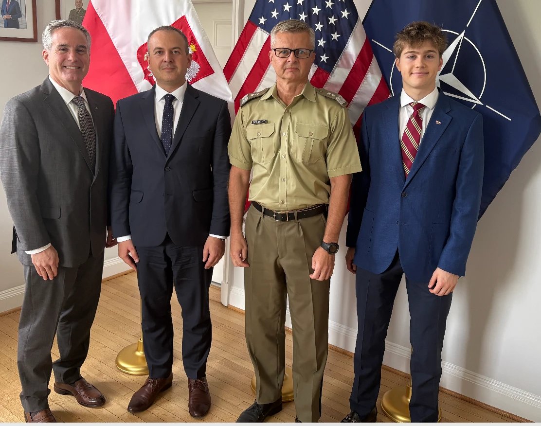 Capitol Group International meeting with General Krzysztof Nolbert, Defense, Military, Naval and Air Attaché at the Embassy of the Republic of Poland, in front of the Polish, American, and NATO flags.